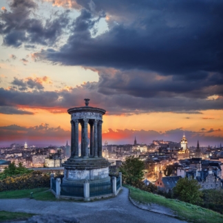 Photograph of Edinburgh's skyline at sunset featuring Calton Hill silhouetted against a vibrant sky